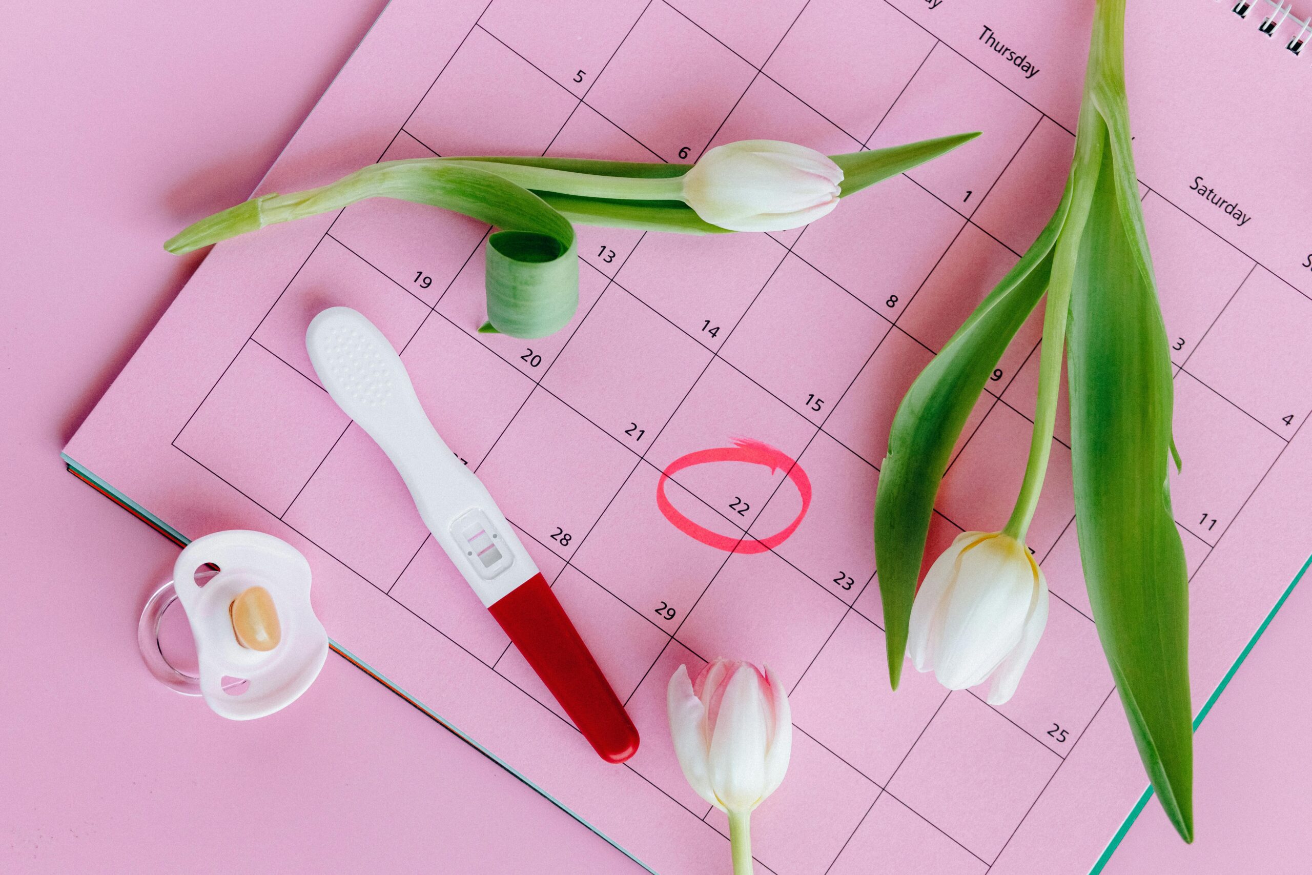 Test de embarazo sobre calendario de seguimiento de la fertilidad y ciclo menstrual